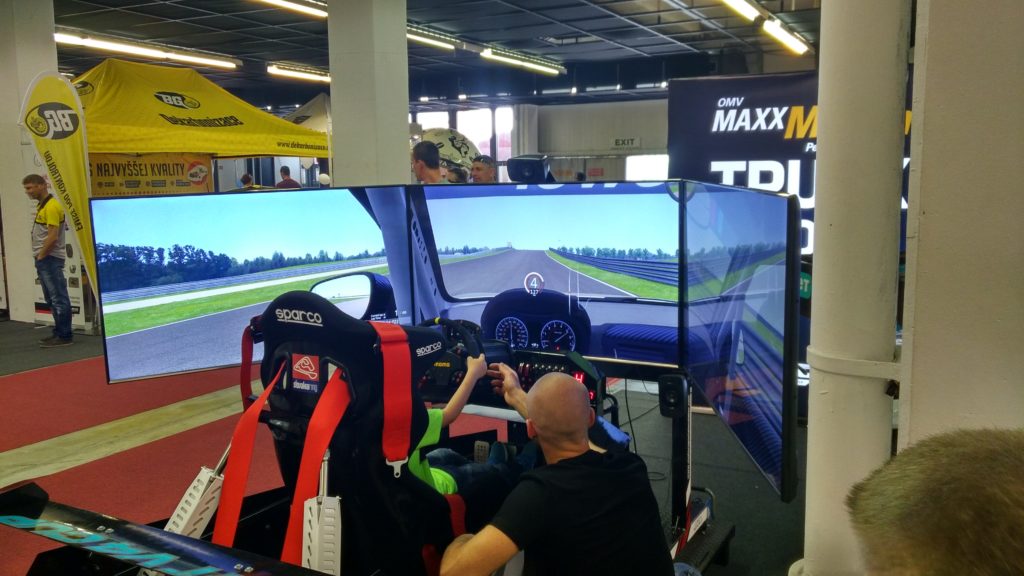 Simulátor s 3 obrazovkami a MOMO volantom, ukazovateľom otáčok a rýchlosti na prístrojovom panely